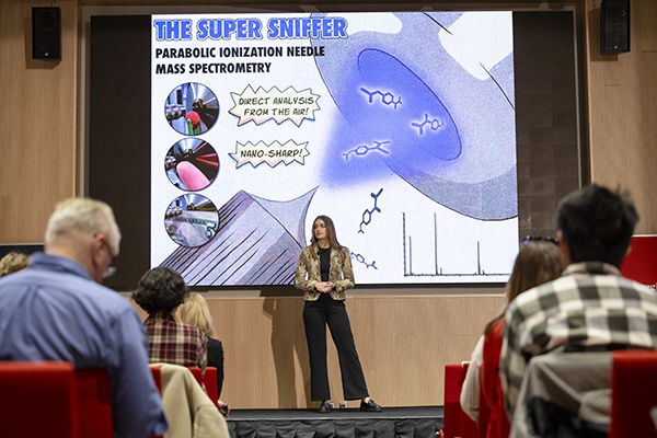 Student presenting with "the super sniffer" on the screen behind her