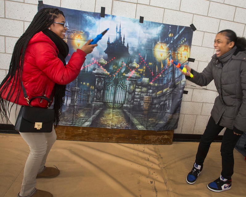 Students with "wands" in front of a picture of a castle